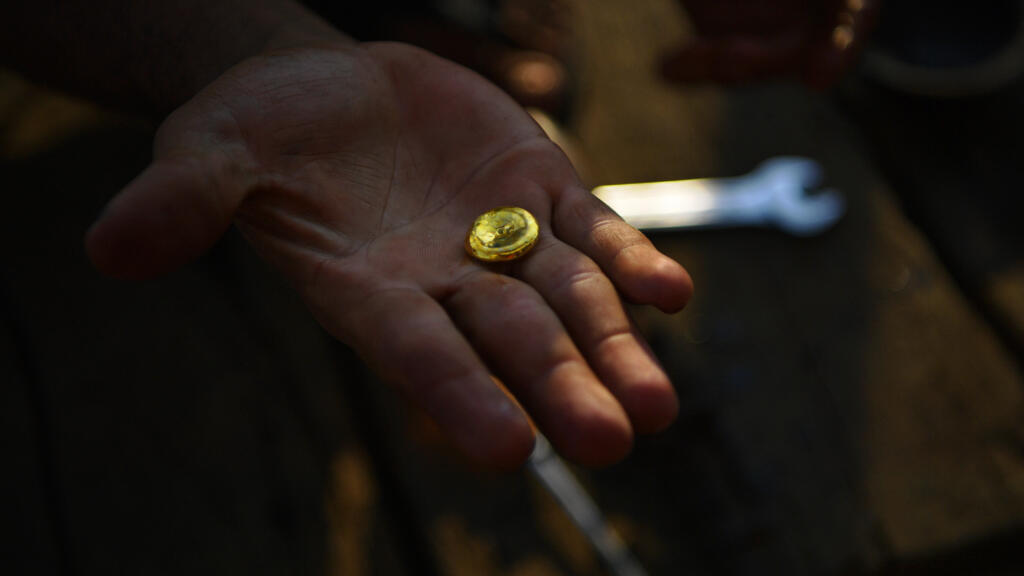 Um garimpeiro ilegal mostra uma pequena pepita de ouro a bordo de seu barco em um rio na bacia Amazônica, ao sul de Porto Velho, no noroeste do estado de Rondônia, em 27 de agosto de 2019.