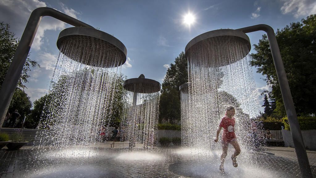 Une enfant se rafraîchit sous une fontaine publique, à Vilnius, le 21 juin 2023.(Photo d'illustration)
