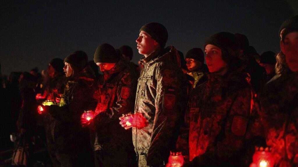 Des militaires ukrainiens tiennent des bougies lors d'une cérémonie commémorative marquant les 1000 jours de la guerre entre la Russie et l'Ukraine à Kiev, en Ukraine, le mardi 19 novembre 2024.