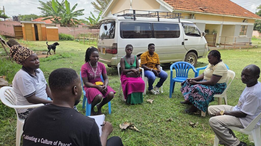 Un groupe de survivants de la LRA, en discussion dans les jardins de l'association du réseau des victimes et enfants de la guerre à Gulu, le 4 septembre 2025.