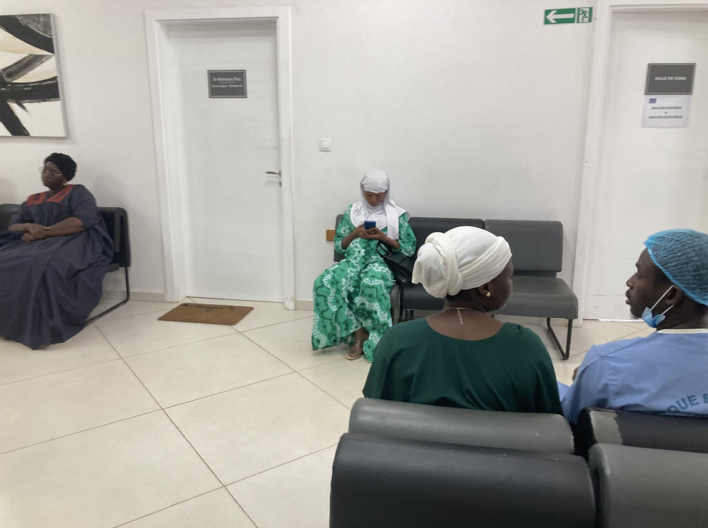 Dans la salle d'attente du docteur Abdoulaye Diop, Amissi et Saliou attendent ensemble leur rendez-vous pour l'échographie du deuxième trimestre.