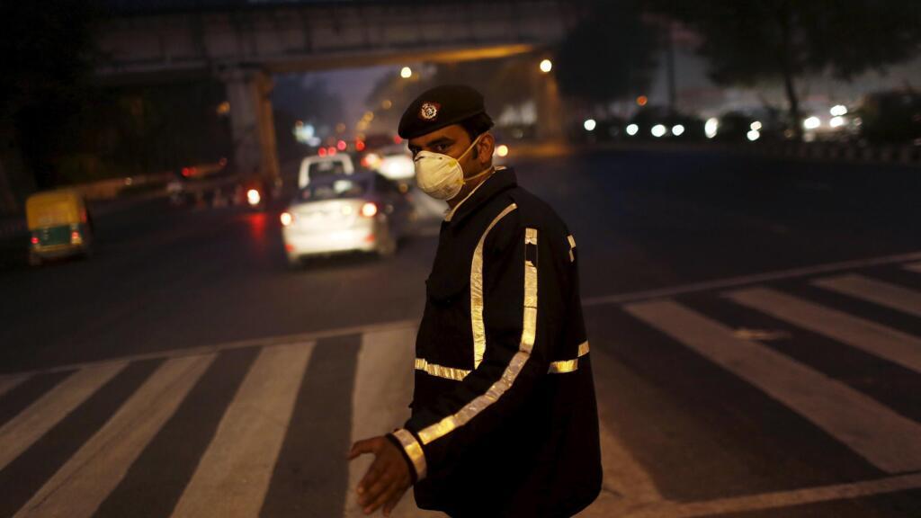 Un policier au milieu de la circulation de New Delhi porte un masque pour se protéger de la pollution.