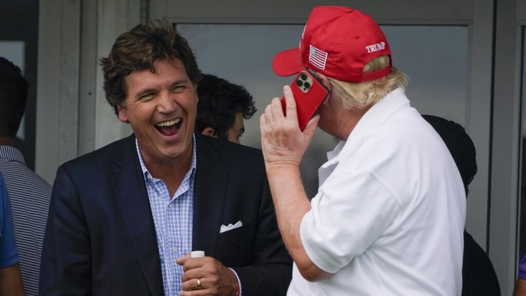 Tucker Carlson, à gauche, s'entretient avec l'ancien président Donald Trump lors de la dernière ronde du tournoi de golf Bedminster Invitational LIV à Bedminster, New Jersey, le dimanche 31 juillet 2022.
