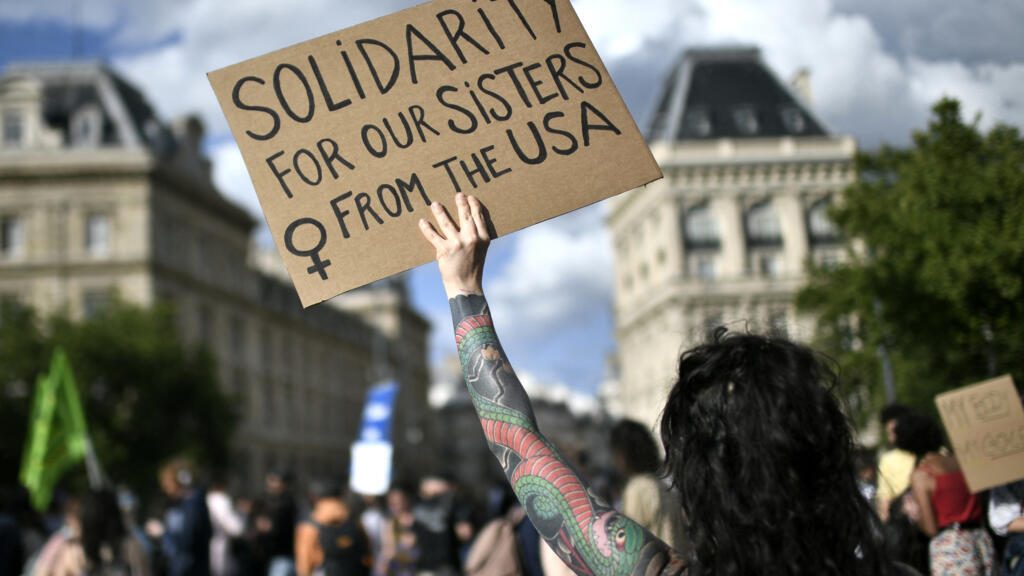 "Solidariedade às nossas irmãs nos Estados Unidos", diz cartaz de manifestante durante protesto realizado em Paris, em 24 de junho.