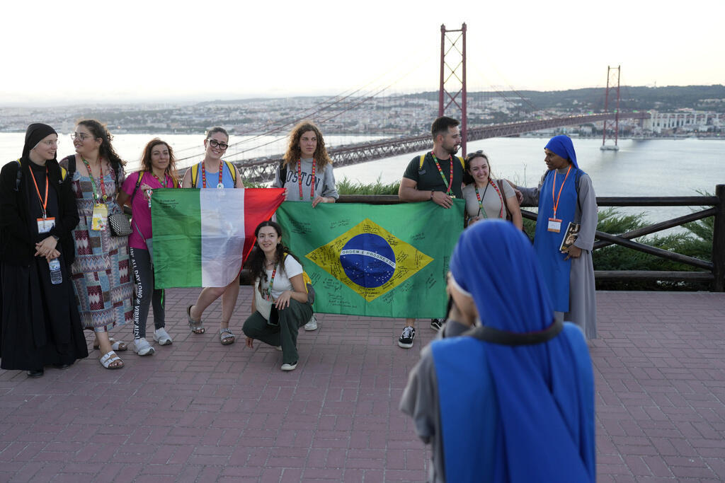 Grupos vindos da Itália e do Brasil posam para foto antes de uma vigília à margem da Jornada Mundial da Juventude, em Almada, Portugal, em 28 de julho de 2023.