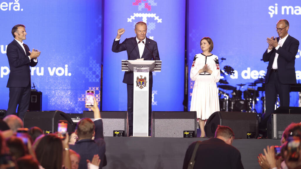 Polish Prime Minister Donald Tusk gestures next to Moldova's President Maia Sandu, German Chancellor Friedrich Merz, right, and French President Emmanuel Macron, left, during a gathering to celebrate