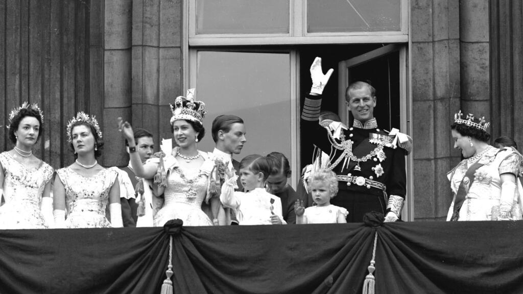 La reine Elizabeth II salue la foule depuis le balcon du palais de Buckingham, après son couronnement, le 2 juin 1953, entourée du prince Philip, le duc d'Édimbourg, du prince Charles, de la princesse Anne et de la Reine mère (à droite).