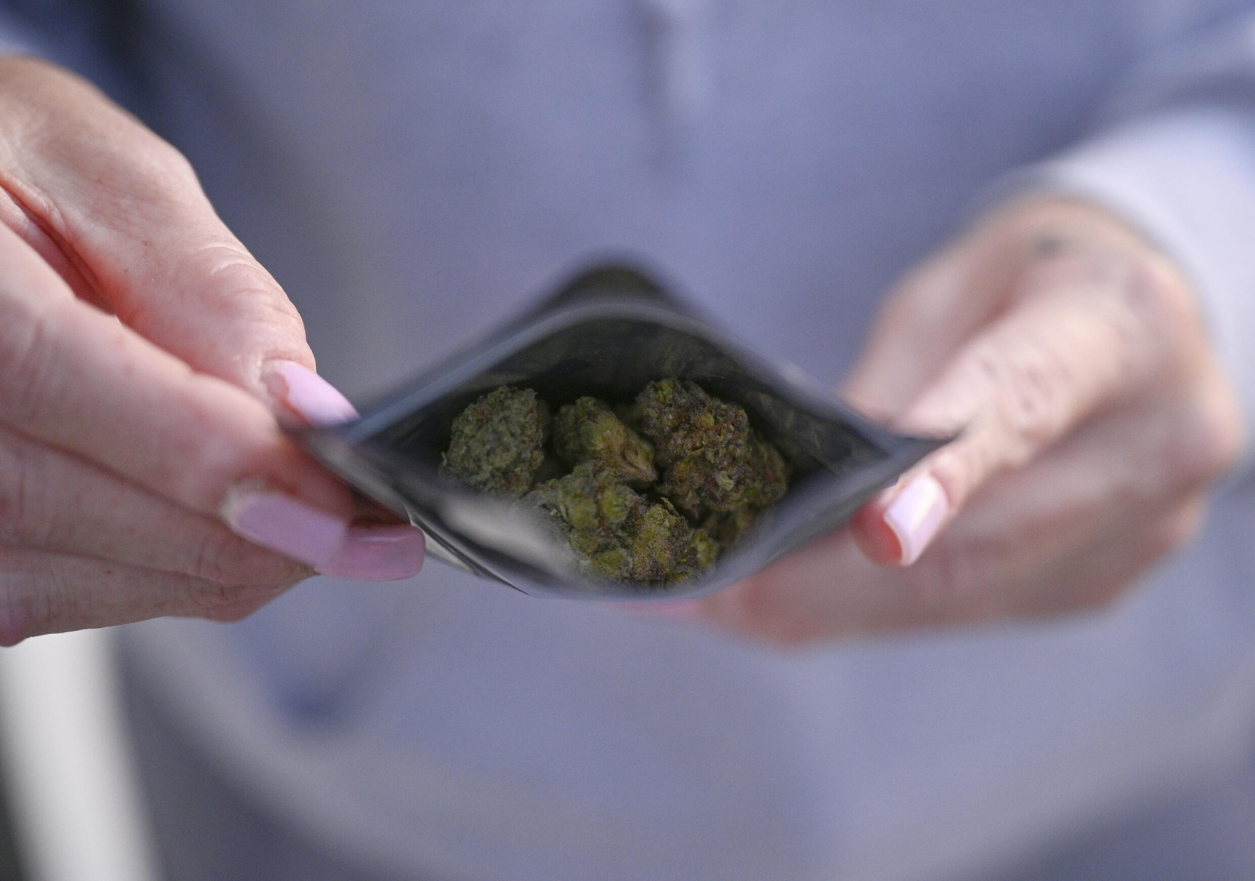 Un cliente con flores de cánnabis compradas en una tienda ilegal en Los Ángeles