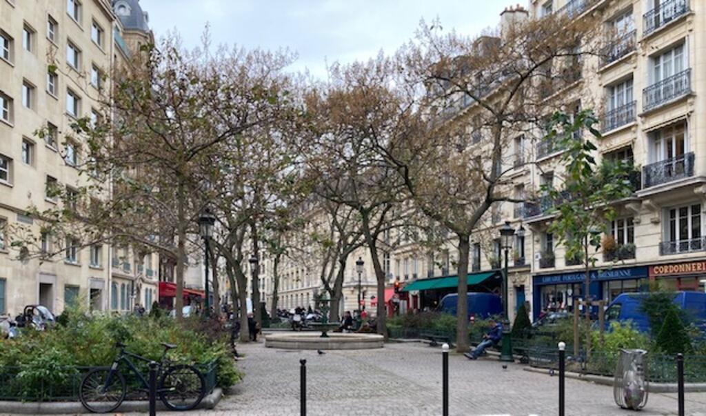 A Praça da Estrapade, com a livraria Portuguesa e Brasileira à direita, e o restaurante "Terra Nera" e a padaria "Moderne" ao fundo.