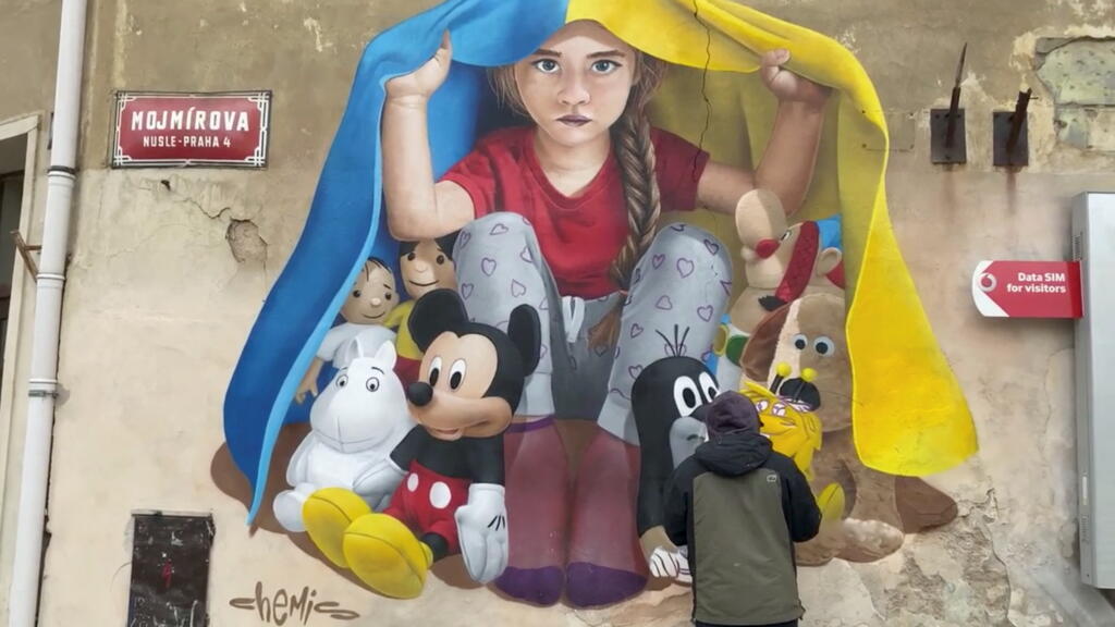 Une peinture murale de l'artiste Chemis représentant une enfant avec le drapeau ukrainien sur sa tête, à Prague, en République tchèque.