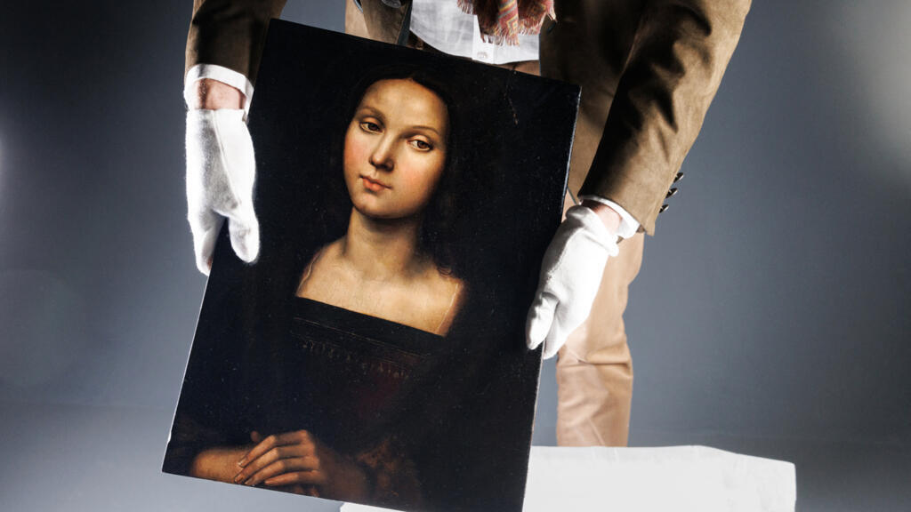Un homme expose à Paris le 21 octobre 2023 un portrait de Marie-Madeleine, un tableau venant d'être authentifié par un groupe d'experts français et italiens comme un chef-d'œuvre du peintre et architecte italien de la Renaissance Raphaël. L'intelligence artificielle pourrait désormais accélérer l'identification de grandes œuvres.