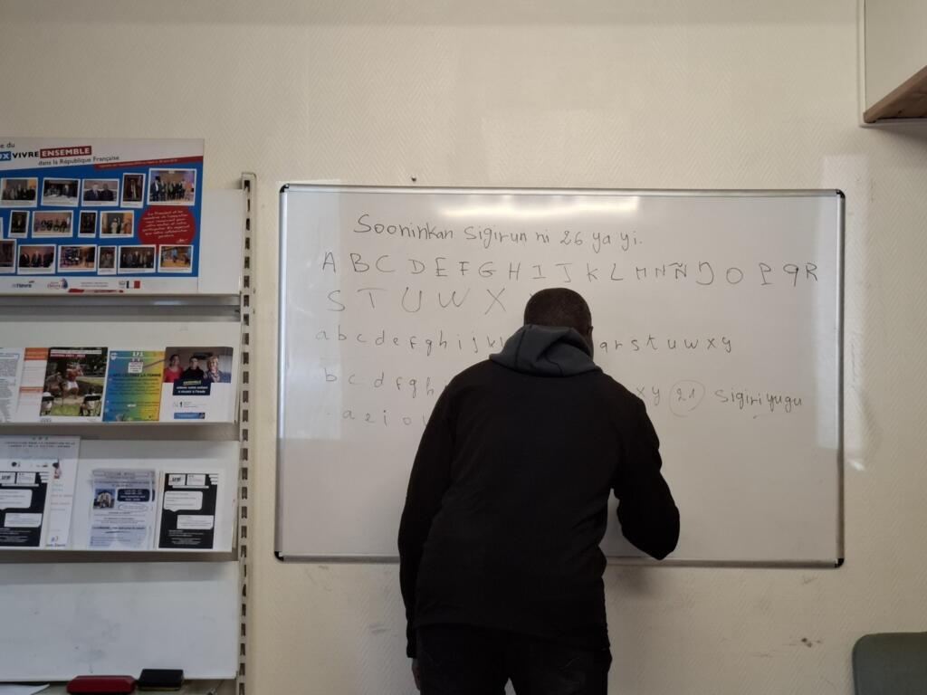 Un apprenant écrivant l'alphabet.