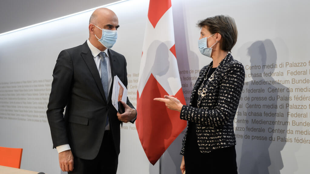 Le ministre de l'Intérieur et de la Santé suisse Alain Berset en discussion avec la présidente suisse Simonetta Sommaruga après une conférence de presse annonçant les nouvelles mesures de lutte contre le Covid-19, à Bern, en Suisse, le 18 octobre 2020.