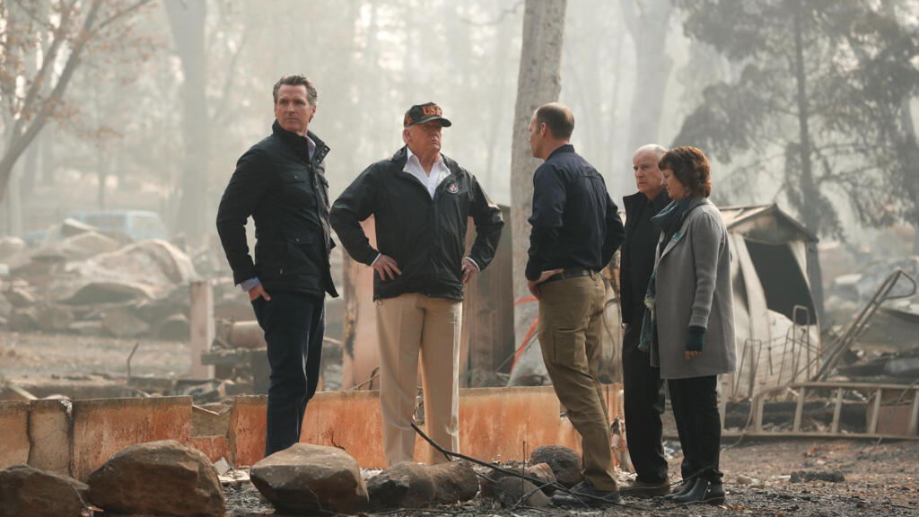 Donald Trump au milieu des ruines à Paradise, en Californie, entouré par le gouverneur de l'Etat, Gavin Newsom (g), et Brock Long, chef de l’Agence fédérale des situations d'urgence, le 17 novembre 2018.