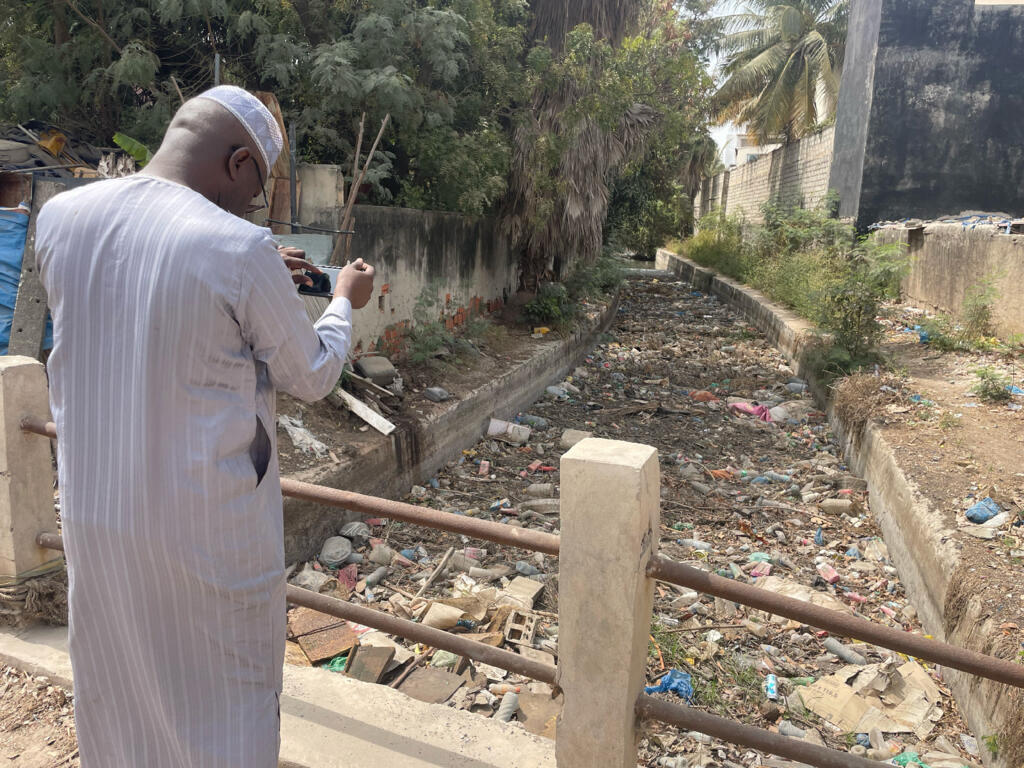 Mbacké Seck devant le canal 6 jonché d'ordures à Hann.