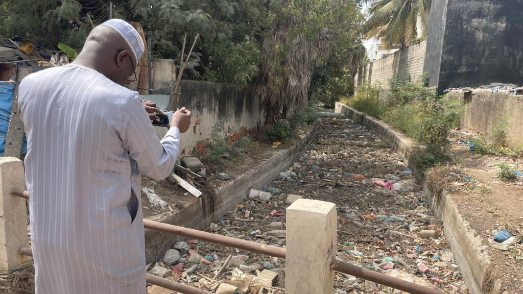 Mbacké Seck devant le canal 6 jonché d'ordures à Hann.
