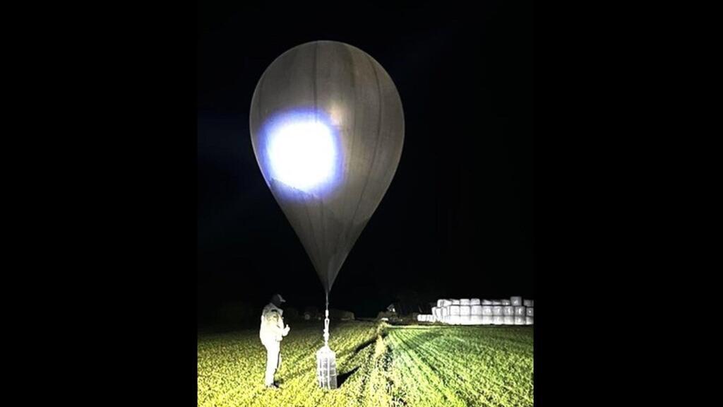 Un grănicer lituanian inspectează un balon folosit pentru traficul de țigarete, la frontiera cu Belarus, locație și dată neprecizată