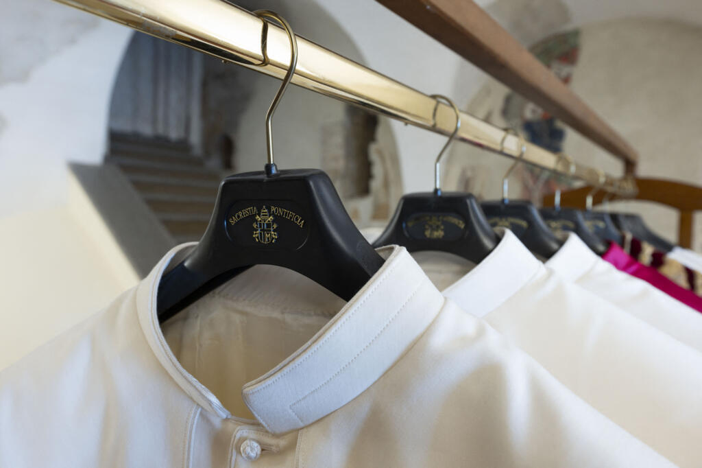 Esta foto, divulgada em 6 de maio de 2025 pela The Vatican Media, mostra as vestes do próximo Papa exibidas em três tamanhos diferentes na "Sala das Lágrimas", uma pequena sala ao lado da Capela Sistina, na véspera do conclave no Vaticano. (Foto de Vatican Media/AFP)