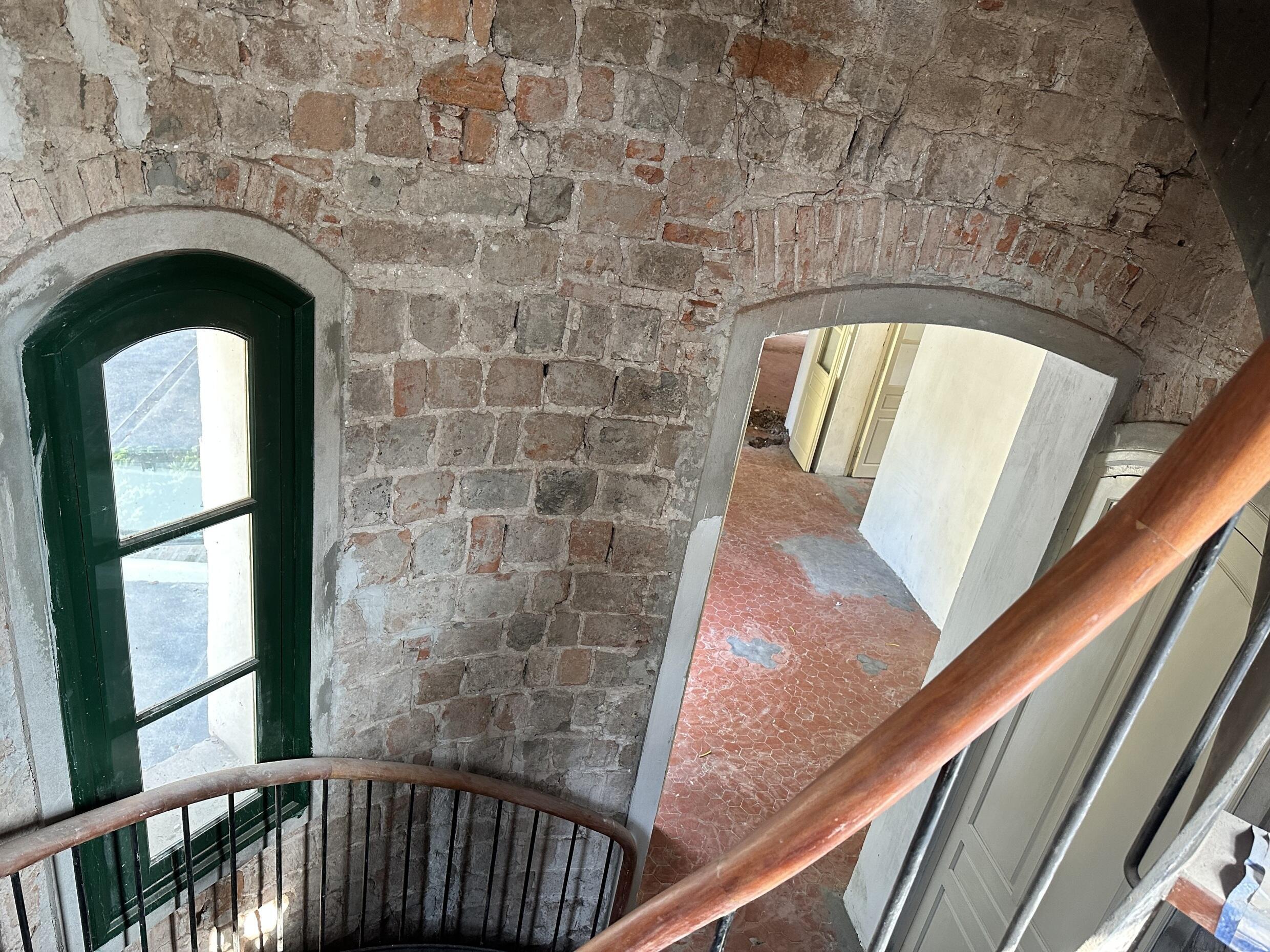 Cầu thang xoắn ốc được làm lại hoàn toàn, dẫn lên tầng hai. Tường để lộ gạch cổ.