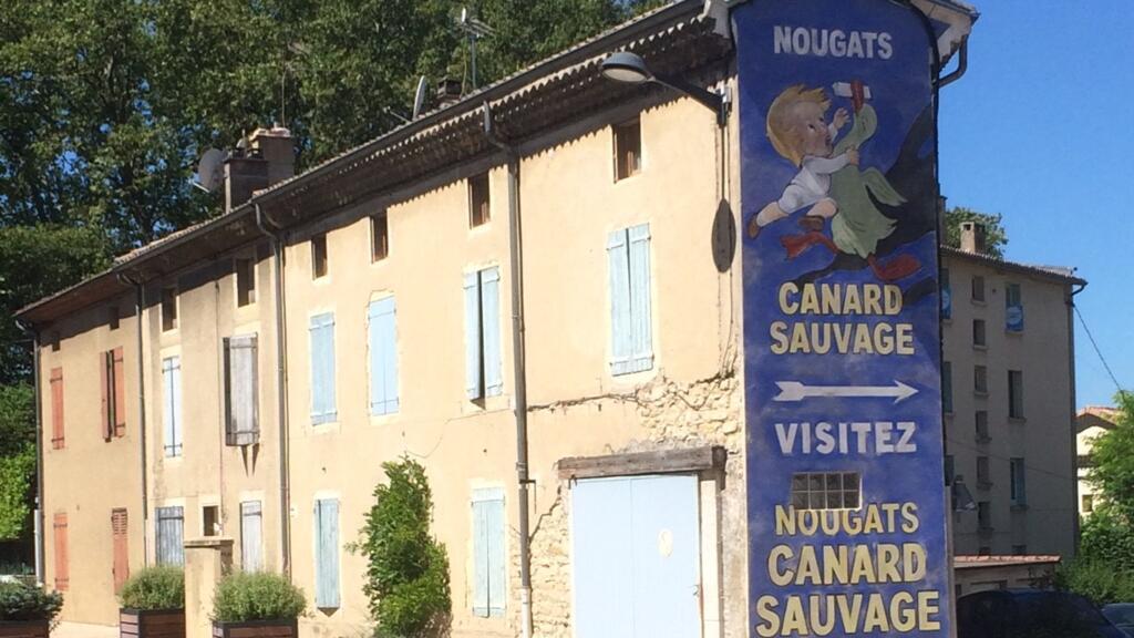 Publicité peinte sur le pignon d'un immeuble sur la Nationale 7.