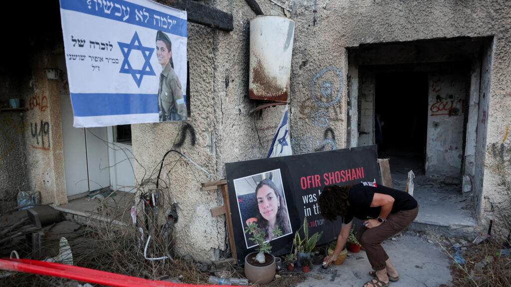 Um morador do kibutz de Kfar Aza coloca uma vela em homenagem a Ofir Shoshani, uma das vítimas do ataque do Hamas, durante uma cerimônia realizada nesta terça-feira, 7 de outubro de 2025.