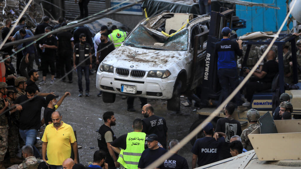Des soldats de l'armée libanaise et des sauveteurs travaillent dans une rue sous un immeuble résidentiel dont les deux derniers étages ont été touchés par une frappe israélienne dans le quartier de Ghobeiri, dans la banlieue sud de Beyrouth, le 24 septembre 2024.