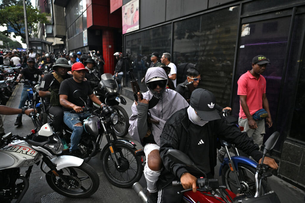 Des partisans armés du président vénézuélien déchu Nicolas Maduro manifestent à moto à Caracas le 4 janvier 2026.