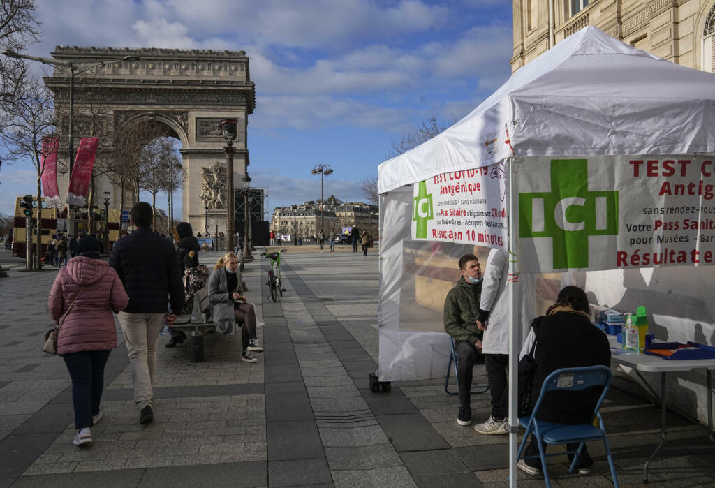 Homem faz teste de antígeno em frente a uma farmácia perto do Arco do Triunfo, em Paris.
