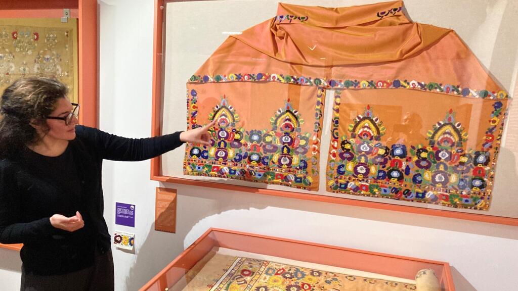 Sarah Bourkaïb devant les broderies à l'IMA de Tourcoing.