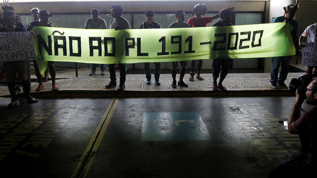 Em frente ao Congresso em Brasília, indígenas protestam contra projeto de lei para permitir a mineração em suas terras.