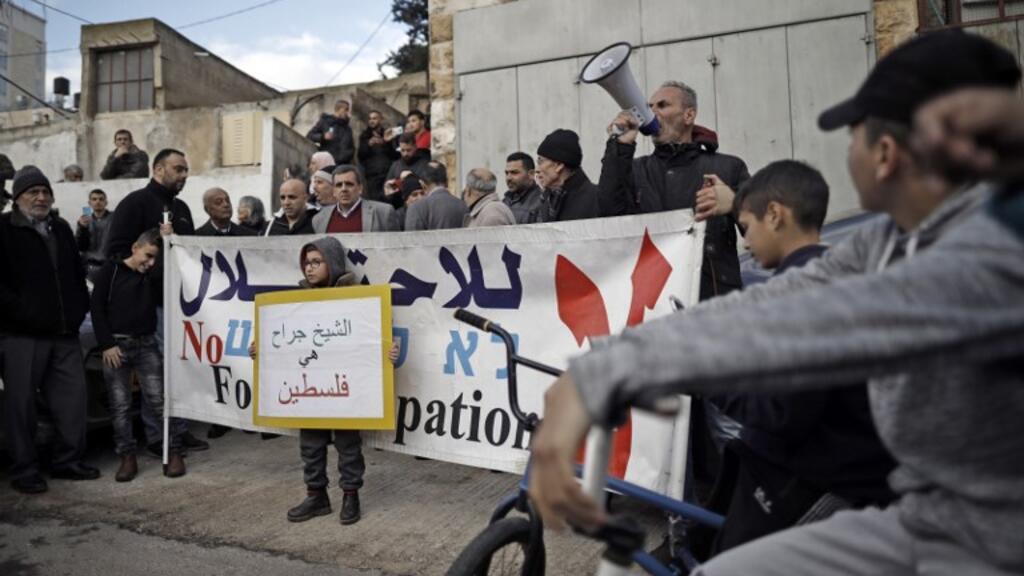Des militants pour la paix scandent des slogans près de la maison de la famille Sabbagh menacée d'expulsion imminente, dans le quartier de Sheikh Jarrah de Jérusalem-Est, le 18 janvier 2019.