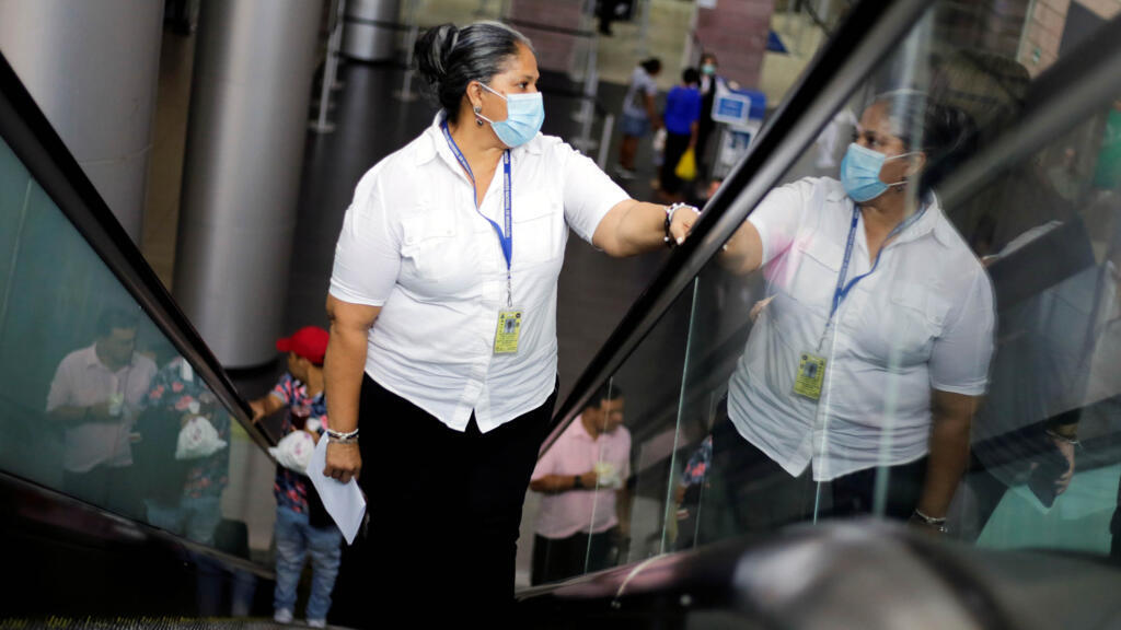 Une femme porte un masque de protection, après les premiers cas de coronavirus dans le pays, à l'aéroport international de Toncontin à Tegucigalpa, au Honduras, le 12 mars 2020.