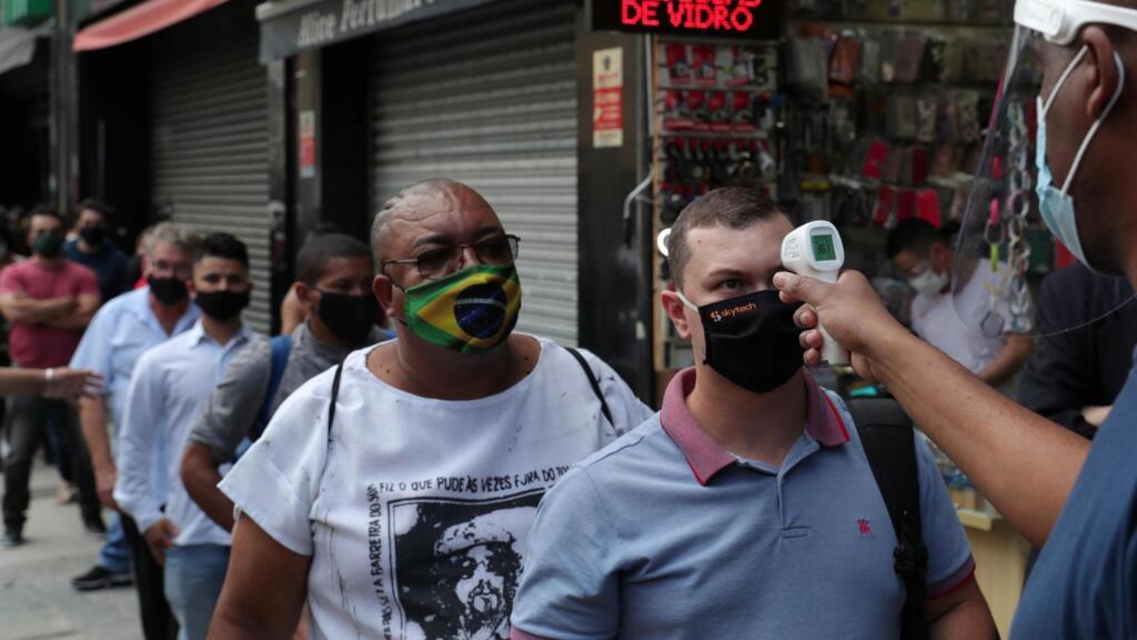 Prise de la température  avant l'accès à un centre commercial de Sao Paulo, le 11 juin 2020.