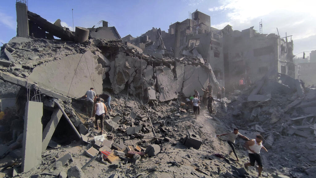 Des Palestiniens inspectent les débris de bâtiments détruits à cause de bombardements israéliens dans le camp de réfugiés de Jabaliya, le 31 octobre 2023.