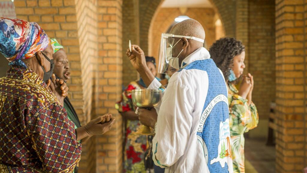 Un prêtre administre la Sainte Communion pendant le service à la cathédrale Notre Dame du Congo à Kinshasa le 16 août 2020 où la Sainte Messe est célébrée pour la première fois depuis le 24 mars, en raison de la pandémie COVID-19 en cours.