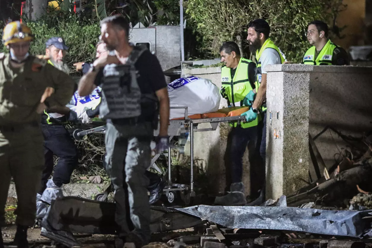 Personal de seguridad y de emergencia israelí trabaja en un lugar blanco de los cohetes lanzados por el movimiento islamista palestino Hamás desde Gaza hacia Israel, en la ciudad israelí de Rishon Lezion, al sur de Tel Aviv.