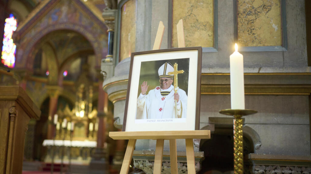 Une photo du défunt pape François se dresse devant l'autel de la basilique Saint-Jean-Baptiste, près de l'ambassade du Vatican, à Berlin, en Allemagne, le lundi 21 avril 2025.