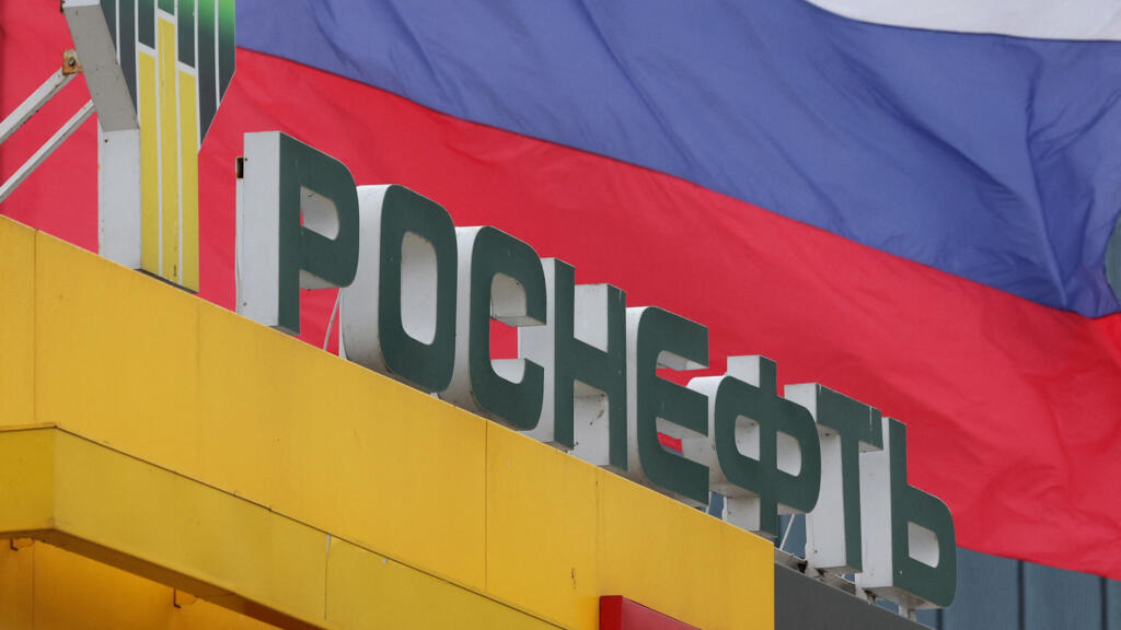 Quốc kỳ Nga tung bay phía sau biển hiệu của tập đoàn dầu mỏ Rosneft tại một trạm xăng ở Saint Petersburg, Nga, ngày 23/10/2025.