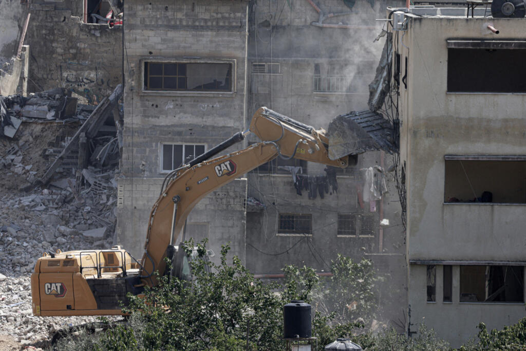 Un bulldozer militaire israélien démolit une maison dans le camp de réfugiés palestiniens de Nur Shams, à l'est de Tulkarem, en Cisjordanie occupée par Israël, le 23 juin 2025, lors d'une opération militaire en cours dans le nord de la Cisjordanie palestinienne.