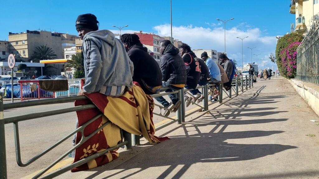 Les migrants subsahariens installés sur les rails d’un tramway en construction observent le va et vient des voitures autour de leur lieu de vie.