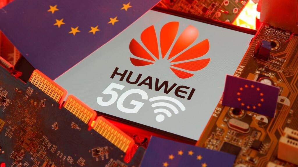 Le drapeau de l'UE et un smartphone avec le logo du réseau Huawei et 5G sont visibles sur une carte mère de PC dans cette illustration prise le 29 janvier 2020 (Illustration).