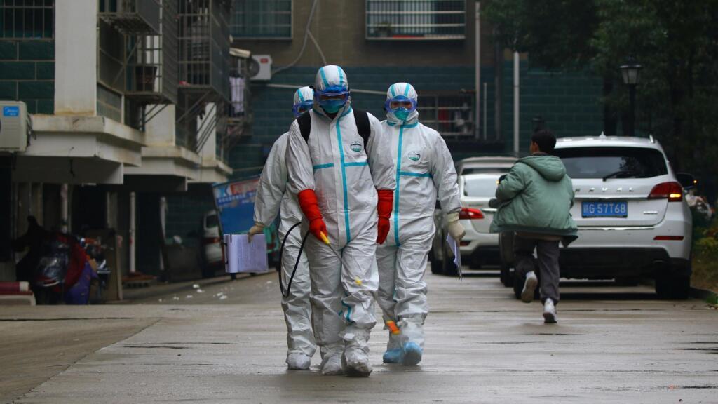 Des travailleurs du département local de prévention et de contrôle des maladies en tenue de protection désinfectent une zone résidentielle à la suite de l'apparition d'un nouveau coronavirus, à Ruichang, province du Jiangxi, Chine, 25 janvier 2020.