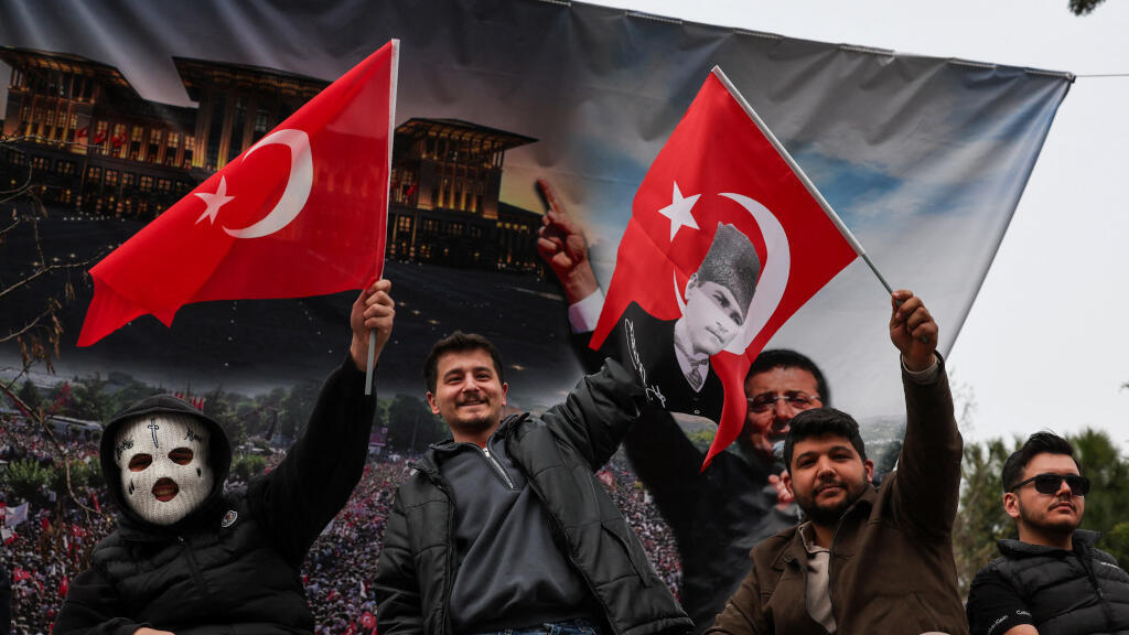 Des gens brandissent des drapeaux turcs le jour où le maire d'Istanbul, Ekrem Imamoglu, a été emprisonné dans le cadre d'une enquête pour corruption, à Istanbul, en Turquie, le 23 mars 2025.