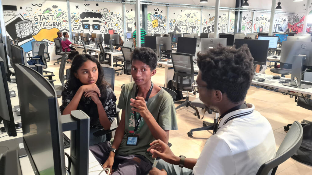 Salle de programmation de l'Ecole 42 Antananarivo. En pleine «Piscine», Malala se fait épauler par deux de ses nouveaux amis pour essayer de «débugger» une ligne de code, qui la bloque pour passer à l'étape suivante. La solidarité et la collaboration sont valorisées et pris en compte dans la sélection des candidats.