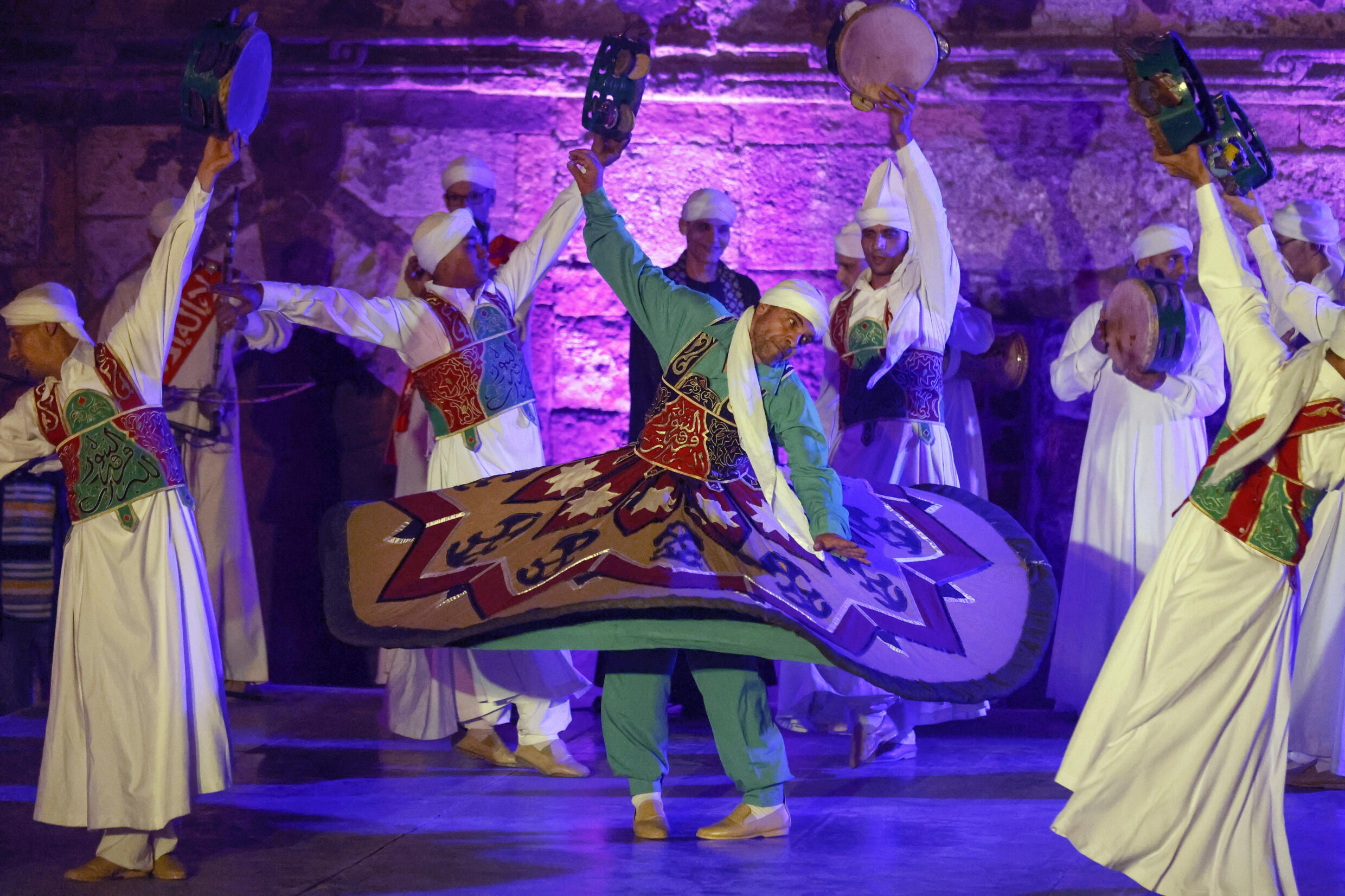 بينما كان الدراويش يدورون ، لا تتوقف تنانيرهم أبدًا ، وتلقي على رؤوسهم وتطوي وترفع علم خطهم الصوفي قبل أن تلتقط تنانيرهم في المنتصف.