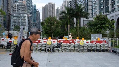 Un homme passe devant des sacs de sables destinés à empêcher des inondations dans une rue de Hong Kong qui se prépare à l'arrivée du super typhon Ragasa, le 23 septembre 2025.