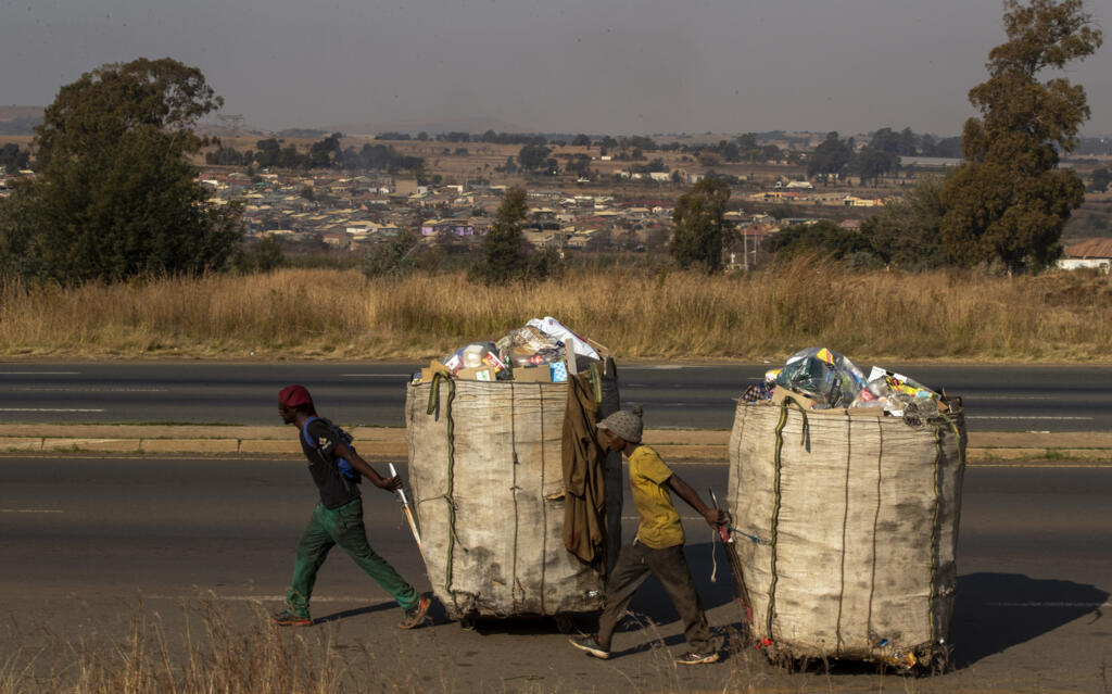 Des hommes tirent des chariots remplis de cartons et de bouteilles en plastique à recycler dans les rues du quartier informel de Phumlamqashi à Vlakfontein, près de Johannesburg, en Afrique du Sud, le mercredi 3 juin 2020. (Image d'illustration)