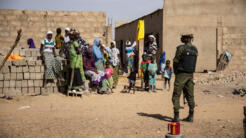 Des déplacés internes à Dori, région du Sahel, avec à leur côté un soldat en patrouille dans la ville, le 3 février 2020