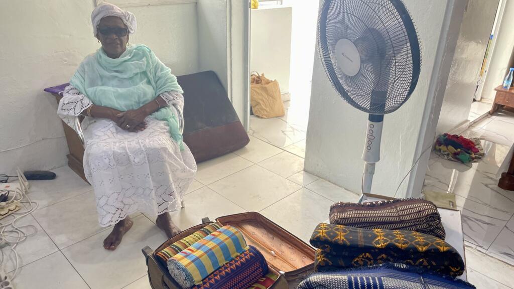 Binta Ndoye, la mère de Marème Sow, entourée de ses pagnes, à Dakar au Sénégal, en septembre 2024.
