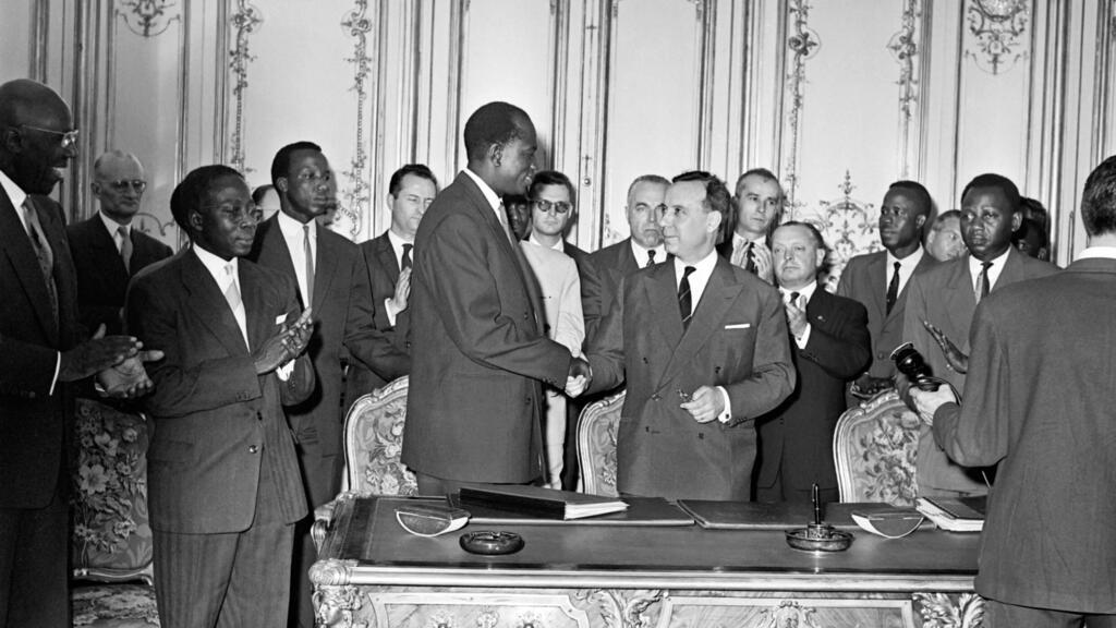 Modibo Keïta, le chef de l'État malien (G) sert la main du Premier ministre français Michel Debré (D), à coté de Mamadou Dia, vice-président du Mali (ext D), lors des négociations qui ont abouti à la proclamation de l'indépendance de la Fédération du Mali, le 20 juin 1960, à Paris.